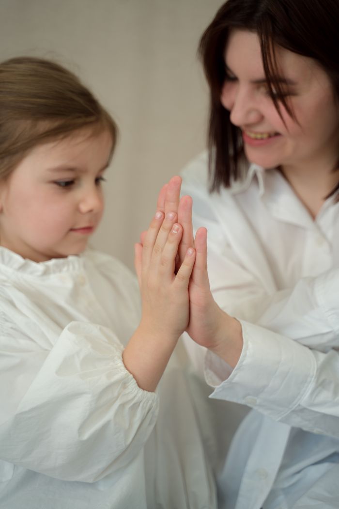 A tender moment between mother and daughter with a cheerful high five.